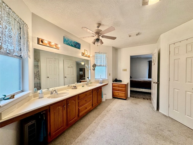 bathroom with vanity, ceiling fan, and a textured ceiling