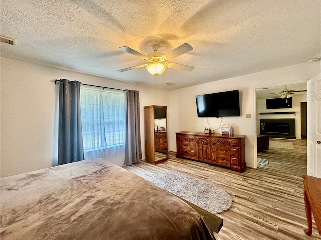 bedroom featuring a textured ceiling, wood-type flooring, and ceiling fan