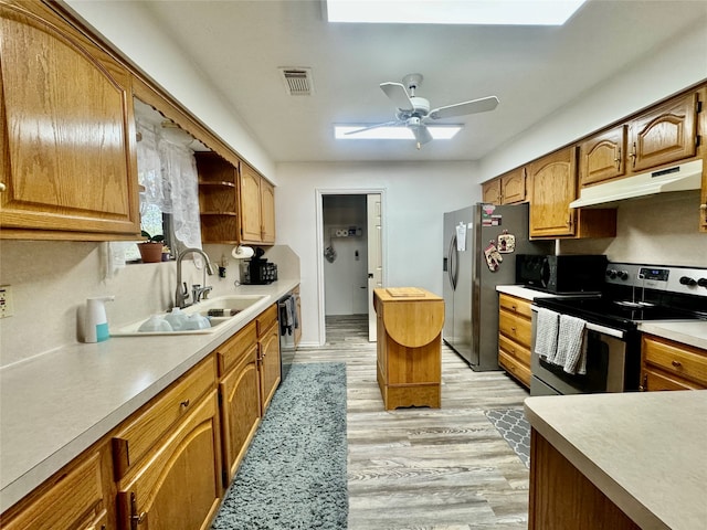 kitchen featuring sink, stainless steel appliances, light wood-type flooring, and ceiling fan