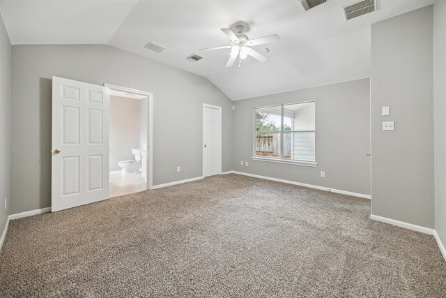 unfurnished bedroom featuring ensuite bathroom, ceiling fan, carpet, and vaulted ceiling