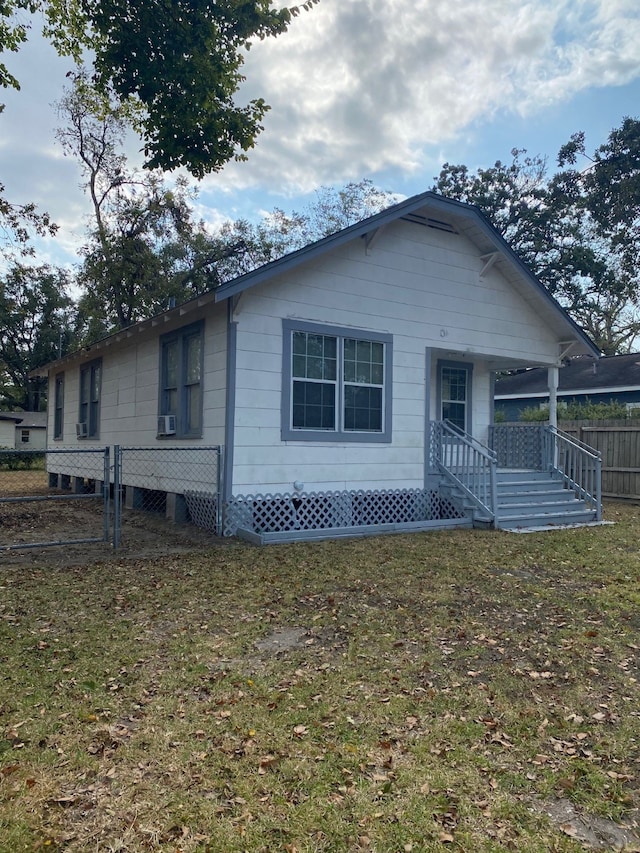 rear view of property with a porch, a yard, and fence