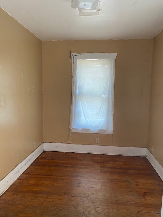 empty room with baseboards and dark wood-style flooring