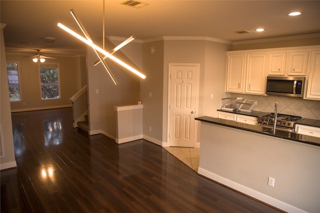 kitchen with dark hardwood / wood-style flooring, stainless steel appliances, white cabinetry, and ceiling fan