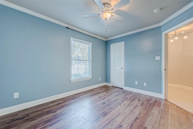 spare room with wood-type flooring, ceiling fan, and ornamental molding