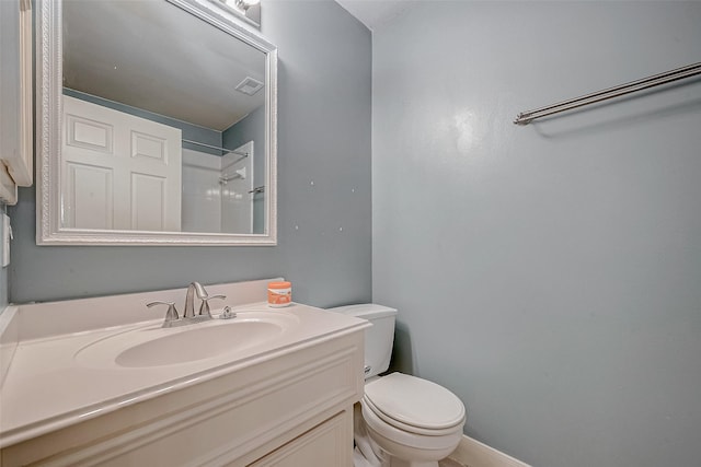 bathroom featuring vanity, toilet, and walk in shower