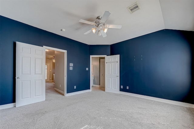 unfurnished bedroom featuring lofted ceiling, light colored carpet, and ceiling fan