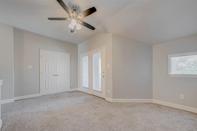 carpeted empty room featuring ceiling fan and lofted ceiling