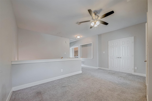 carpeted spare room featuring ceiling fan