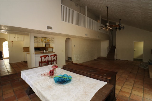 20 Ranchero Rd, College Station, TX 77845 - dining room featuring dark tile patterned flooring, high vaulted ceiling, and ceiling fan