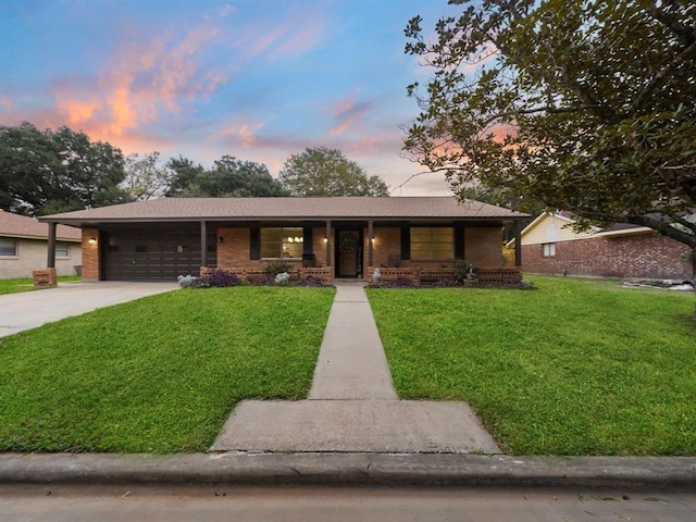 ranch-style home with a front lawn, an attached garage, brick siding, and driveway