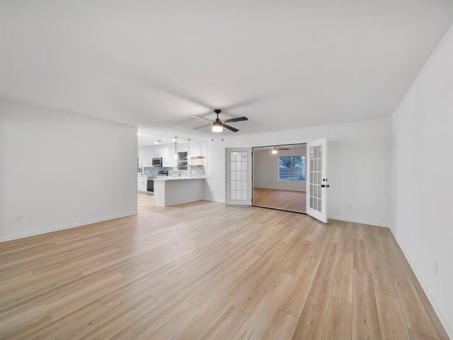 unfurnished living room featuring french doors, baseboards, ceiling fan, and light wood finished floors