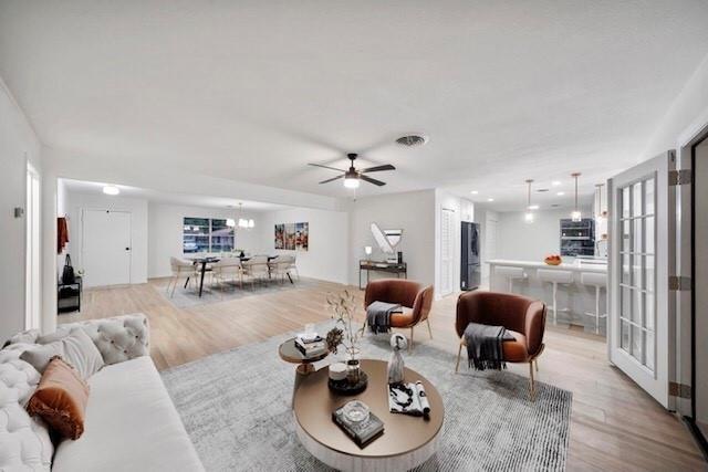 living room with ceiling fan and light hardwood / wood-style flooring