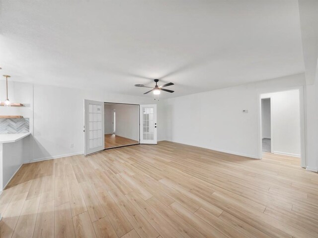 unfurnished living room featuring french doors, light hardwood / wood-style flooring, and ceiling fan