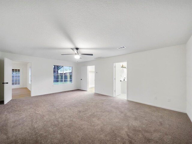 carpeted spare room with ceiling fan and a textured ceiling