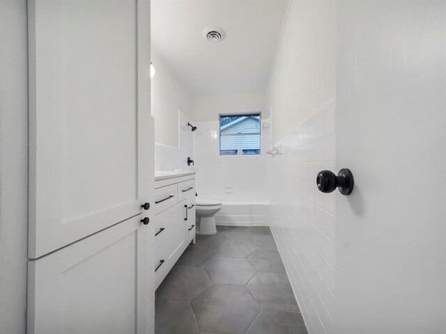 bathroom with tile patterned floors, a shower, vanity, and toilet