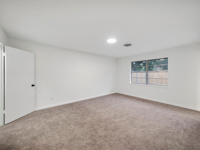 carpeted spare room with baseboards and visible vents