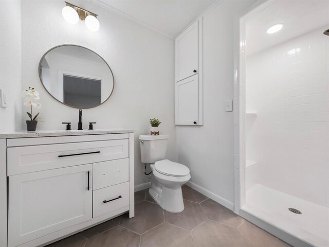 full bath with tile patterned floors, tiled shower, toilet, and vanity