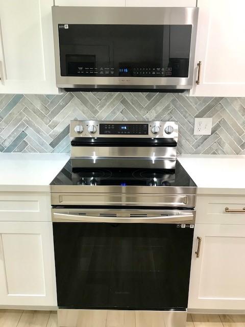 kitchen featuring stainless steel appliances, decorative backsplash, and light countertops