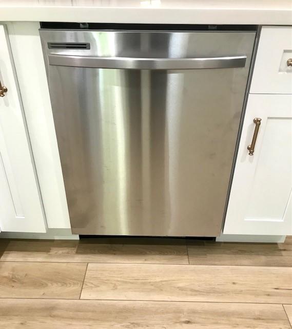 details featuring white cabinets, light wood-type flooring, and dishwasher