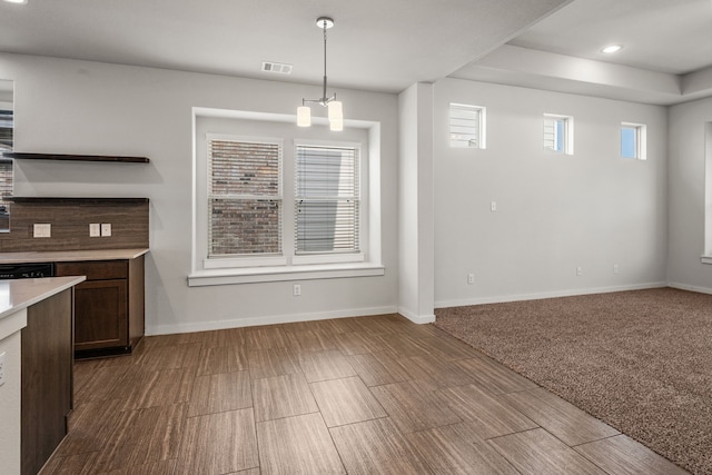 unfurnished dining area featuring light carpet and a chandelier