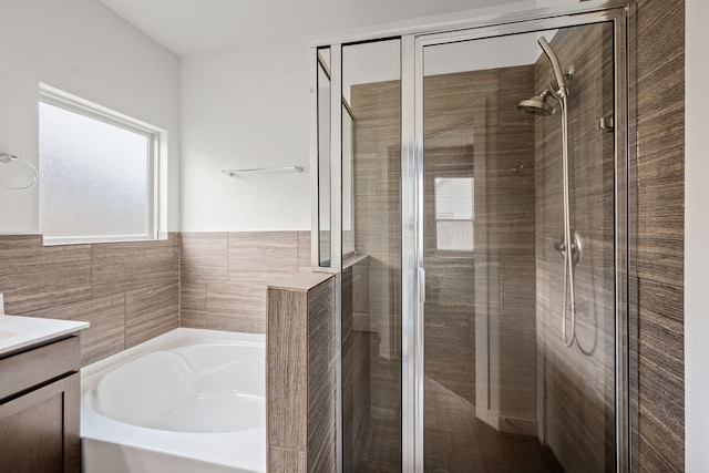 bathroom featuring vanity and independent shower and bath