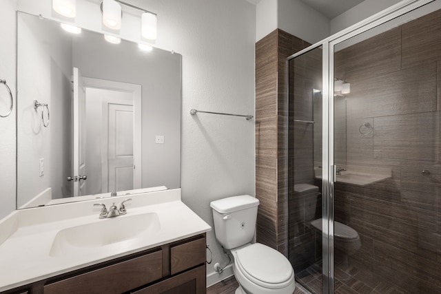 bathroom featuring toilet, walk in shower, and vanity