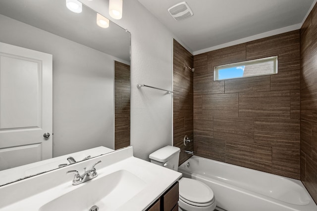 full bathroom featuring tiled shower / bath, vanity, and toilet