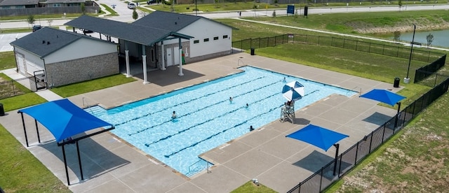 view of pool featuring a patio area, an outbuilding, and a lawn