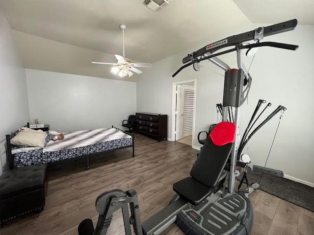 bedroom with dark wood-type flooring, vaulted ceiling, and ceiling fan