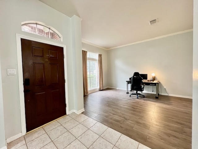 foyer entrance featuring ornamental molding and light hardwood / wood-style flooring