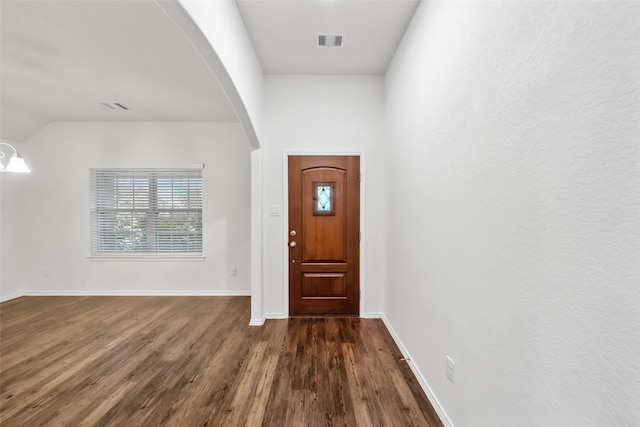 foyer entrance featuring vaulted ceiling and dark hardwood / wood-style flooring