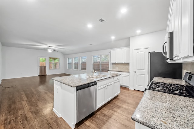 kitchen featuring white cabinets, stainless steel appliances, a center island with sink, and a wealth of natural light