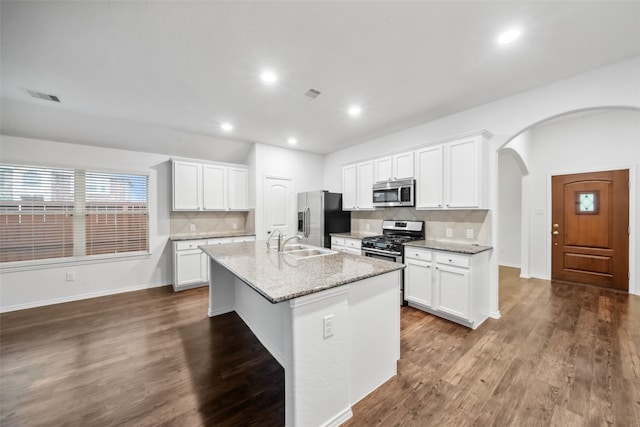 kitchen featuring white cabinetry, appliances with stainless steel finishes, and a center island with sink