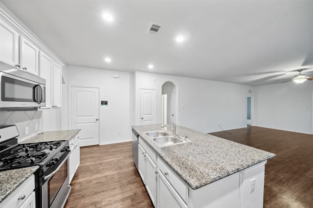 kitchen featuring sink, an island with sink, white cabinetry, stainless steel appliances, and hardwood / wood-style flooring