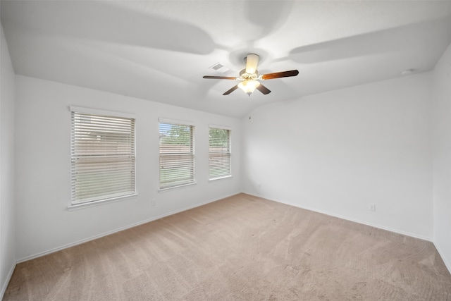 empty room with ceiling fan, vaulted ceiling, and light colored carpet