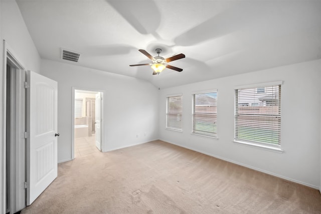 unfurnished bedroom featuring connected bathroom, light colored carpet, and ceiling fan