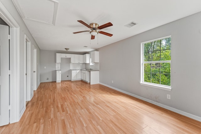 unfurnished living room with light wood-type flooring and ceiling fan