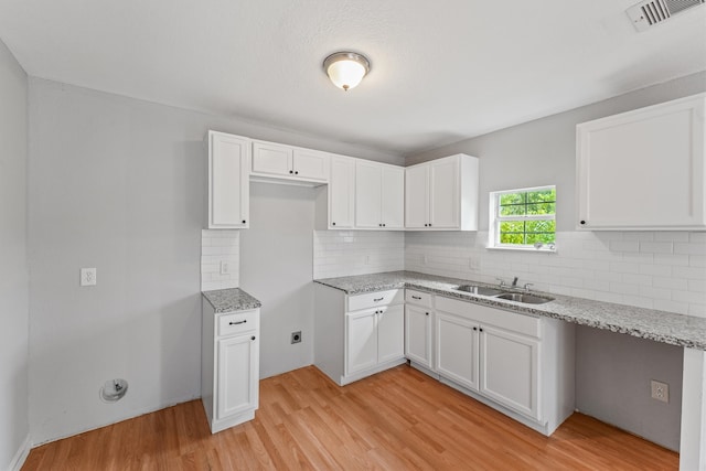 kitchen featuring white cabinetry, light hardwood / wood-style flooring, and sink