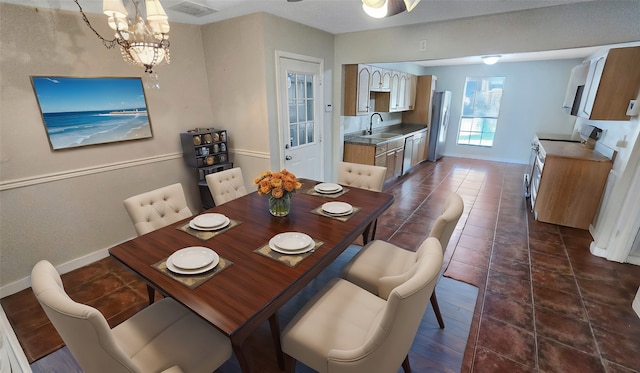 tiled dining area with sink and a chandelier