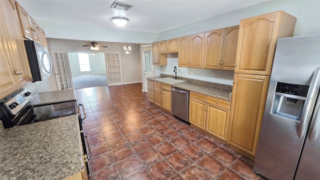 kitchen with appliances with stainless steel finishes, french doors, sink, and ceiling fan with notable chandelier