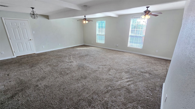 carpeted empty room with beamed ceiling and ceiling fan