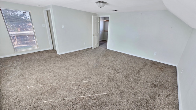 carpeted spare room with lofted ceiling