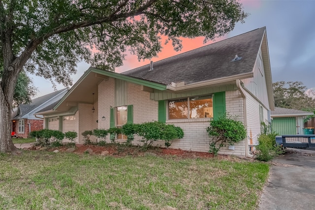 property exterior at dusk with a garage and a lawn