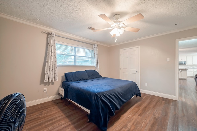 bedroom featuring dark wood-type flooring, ceiling fan, crown molding, and a textured ceiling