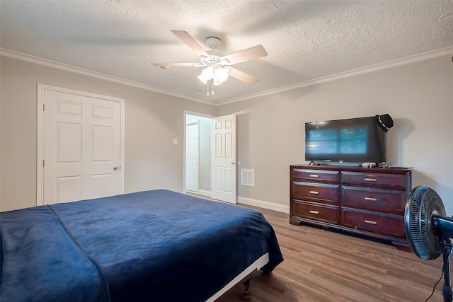 bedroom featuring ceiling fan, ornamental molding, a textured ceiling, and light hardwood / wood-style floors