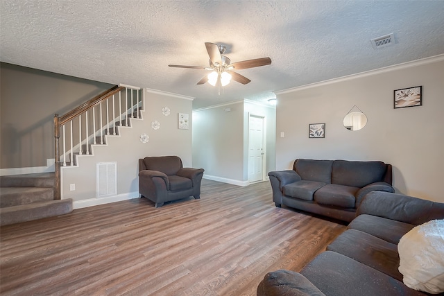 living room featuring ornamental molding, hardwood / wood-style floors, a textured ceiling, and ceiling fan