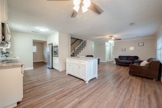 kitchen featuring appliances with stainless steel finishes, white cabinets, and light hardwood / wood-style flooring