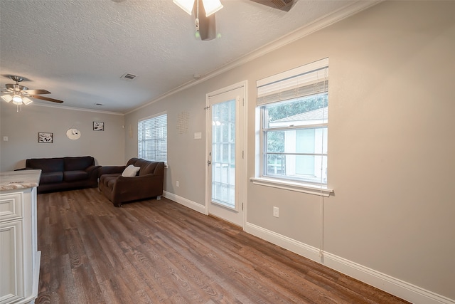 living room featuring ceiling fan, a healthy amount of sunlight, wood-type flooring, and a textured ceiling