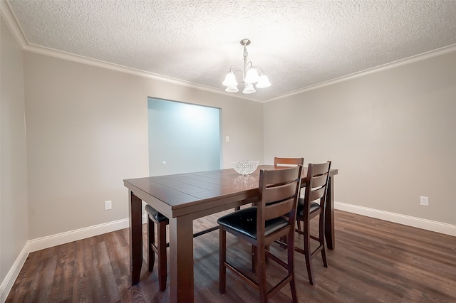 dining space featuring dark wood-type flooring, crown molding, a textured ceiling, and a chandelier