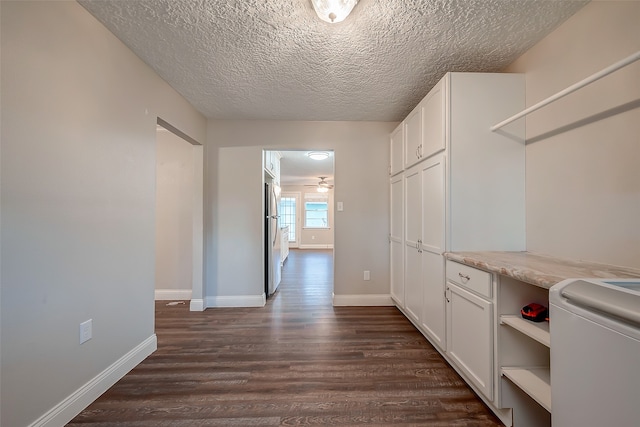 interior space with a textured ceiling, dark hardwood / wood-style floors, and washer / clothes dryer